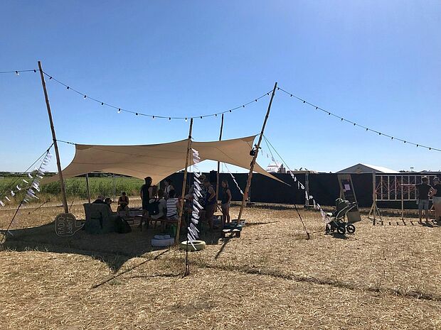 Menschen unter einem offenen Zelt auf dem Skandalös Festival.